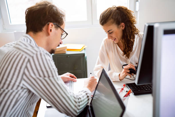istock Two colleagues discussing business at their workplace 1455770868