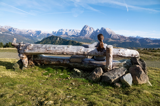 Young teenage girl enjoying the view from the mountain top. Photo taken in Dolomites / Italy