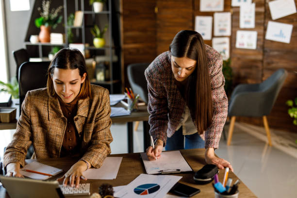 istock Two businesswomen chatting about project ideas when reviewing paperwork and having a briefing 1455772725