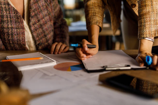 istock Two unrecognizable young businesswomen co-working on a project together 1455772737
