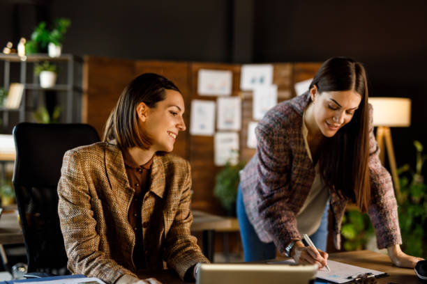 istock Two businesswomen chatting about project ideas when reviewing paperwork and having a briefing 1455772742