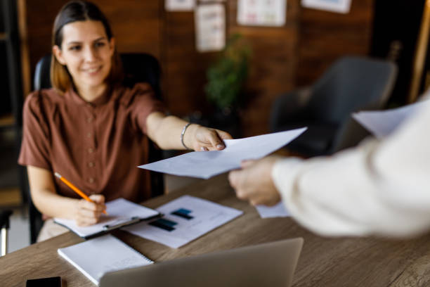 istock Businesswoman handing her colleague a document 1455773121