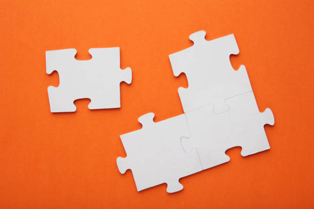 istock Four white puzzle pieces on orange background 1455774537