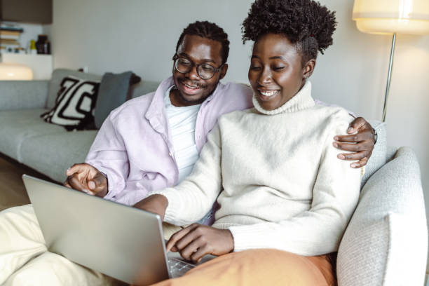 istock Young African-American couple using laptop at home 1455777109