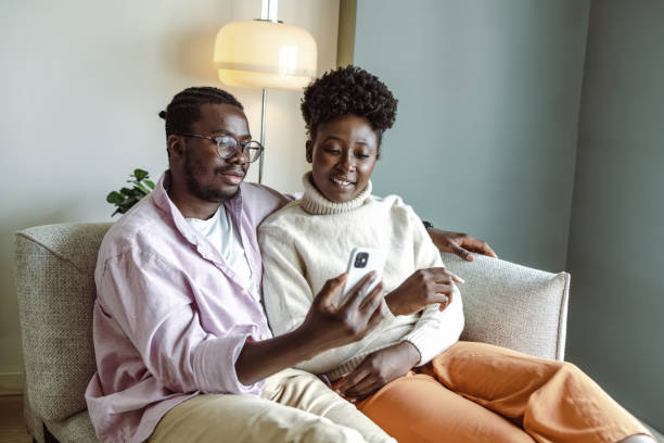 istock Happy African-American couple using smart phone at home 1455777182