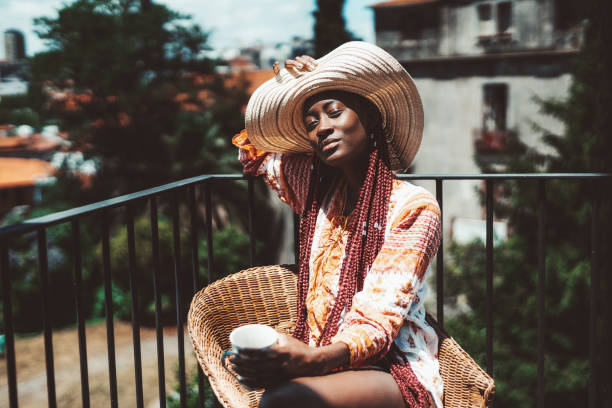istock Black girl catching sun on a balcony 1455777460