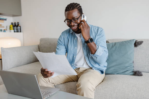 istock Young man talking on the phone and holding documents 1455777534