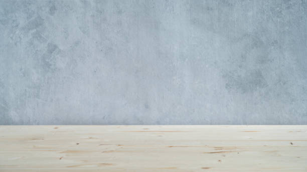 istock A light wooden table top with free space for installing a product or layout on a blue textured background. 1455778845