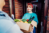 Home fresh food delivery. Woman taking cardboard box with vegetables and fruits. Support local farmer food production. New Start of a healthy life, weight loss concept. Online food order. Recipe box