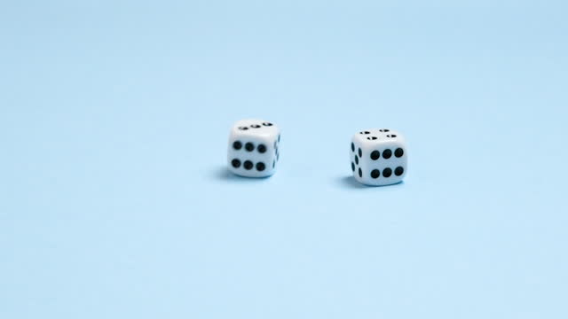 Slow motion full HD view on two dice fall on a blue background and rotate. Gambling or board games concept