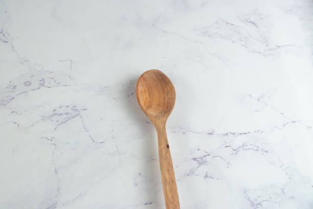 istock Wooden Spoon isolated on table top view 1455780503