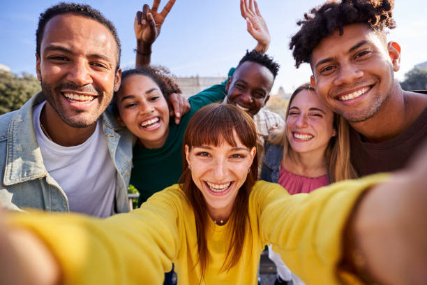istock Multiethnic group of friends taking a selfie outdoors, having fun in sunny day. 1455783097