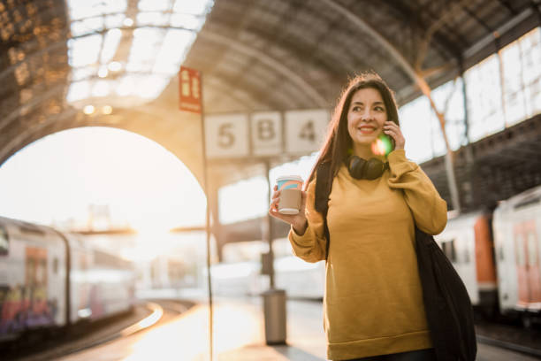 istock A mature beautiful Spanish woman is using a mobile phone at a train station while waiting to get into a train car 1455784113