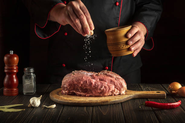 istock The chef sprinkles raw meat with salt. Preparing fresh meat before roasting. Menu concept for restaurant or hotel. Asian cuisine 1455785874