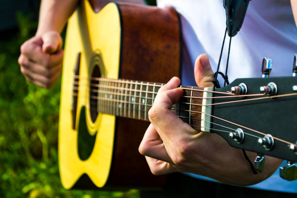 istock Happy young man playing guitar outside the home 1455786104