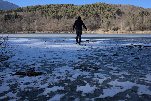 Reckless man walks on frozen lake in danger of drowning in icy waters