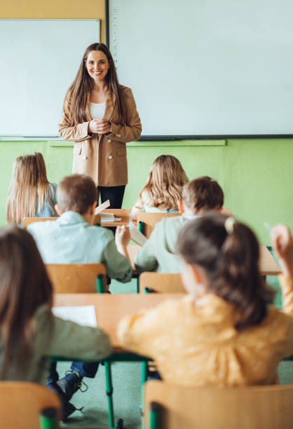 istock Female teacher teaching students during lecture in classroom 1455787572
