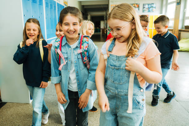 istock happy elementary students walking togetherness in corridor after school 1455787727