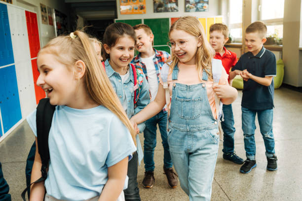 istock Smiling elementary students walking togetherness in corridor after school 1455788201