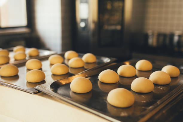 istock Raw dough buns on a tray at the kitchen. 1455790464