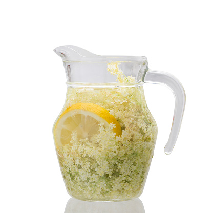 Homemade elderflower syrup drink in a glass jug