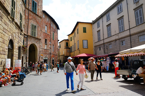 Lucca, Italy – July 16, 2015: The group of people walking through the street in Italy, Lucca