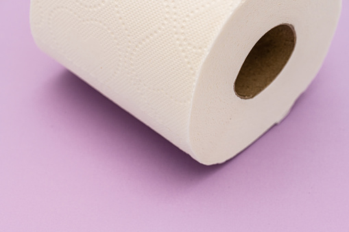 Roll of toilet paper on purple table