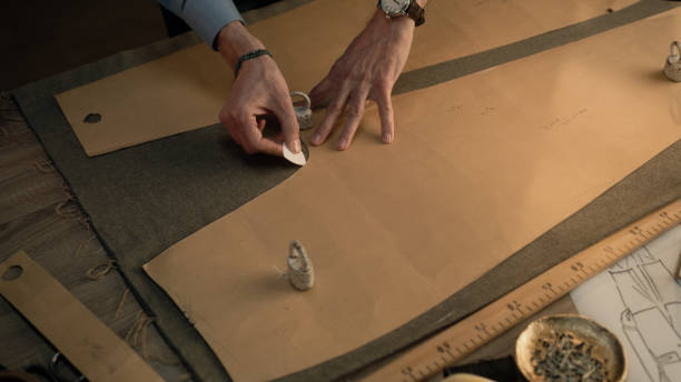 istock Male tailor draws sketch on fabric 1455812126