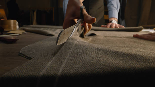 Close-up shot of tailor cutting textile
