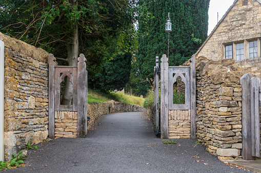 Old Wooden gate entrance to an old English Church in the Cotswolds