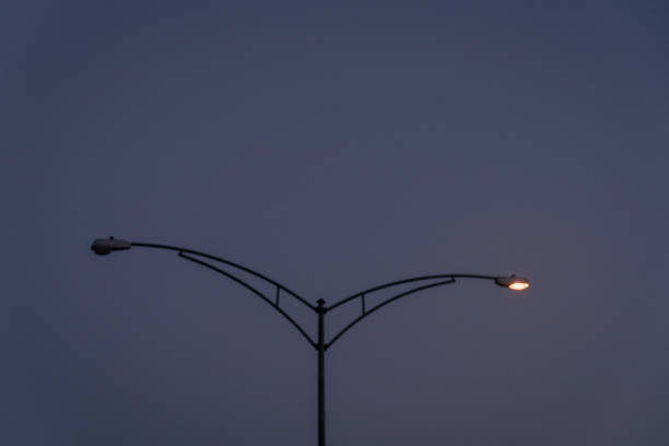 A tall street lamp with a blue sky in the background