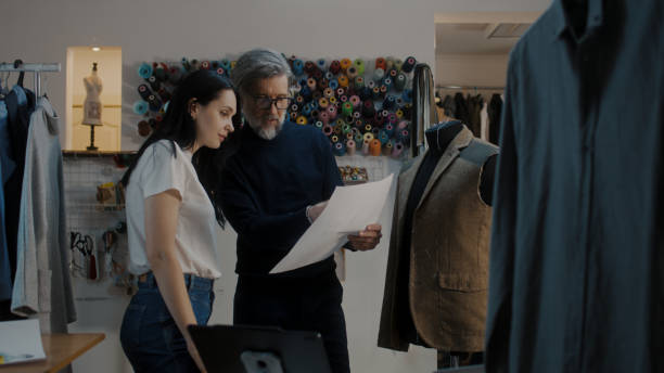 istock Designer discusses sketch with seamstress 1455816359