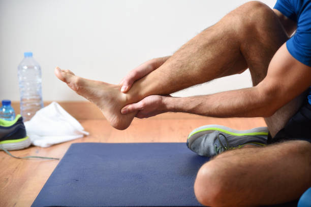 Detail of man doing sports with ankle pain stock photo