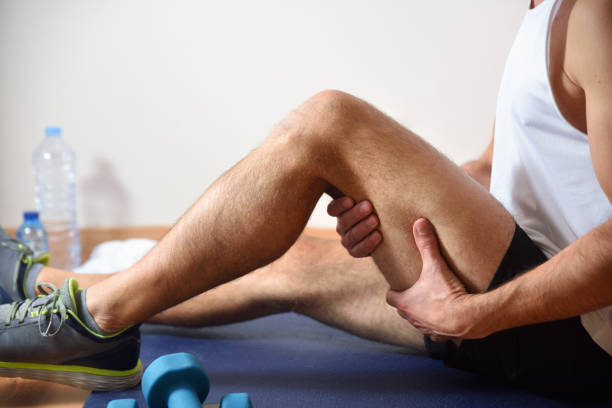 Detail of man doing sports with hamstrings pain Detail of man doing sports with hamstrings pain holding himself with his hand sitting on a mat. Side view hamstring injury stock pictures, royalty-free photos & images