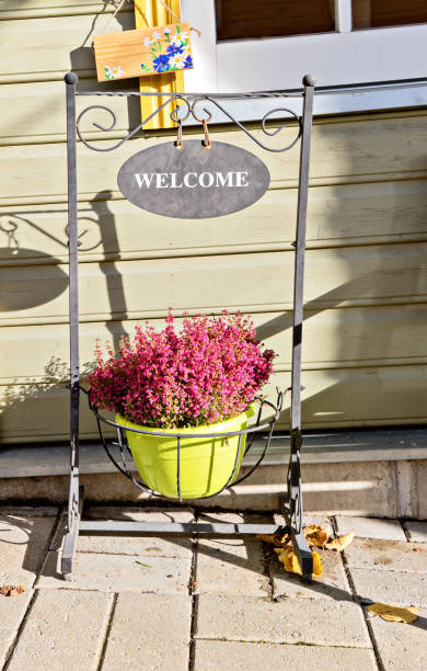 istock Forged sign stand with text Welcome and blooming heather in pot 1455831182