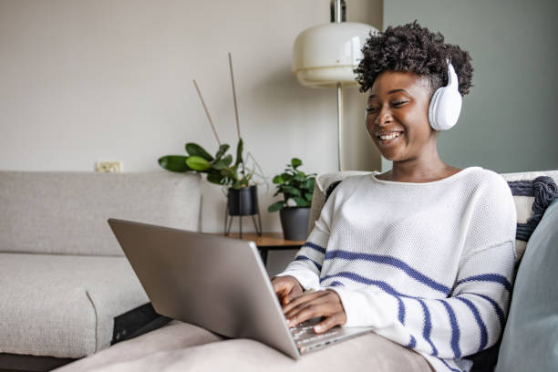 istock A young woman with wireless headphones using a laptop 1455833838