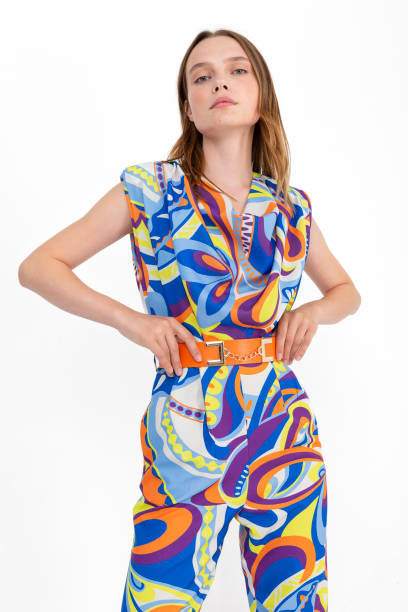 istock Blonde girl on a white background, wearing a multi-colored and patterned short sleeved blouse and trousers. 1455834755