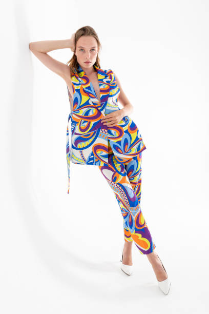 istock Blonde girl on a white background, wearing a multi-colored and patterned jacket and trousers. 1455834775