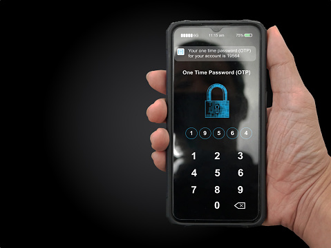 A hand holding a smartphone with filled up one time password for the validation process, Mobile OTP secure verification method, 2-Step authentication concept.