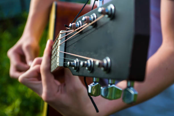 istock A young guy plays guitar, music in the fresh air. 1455834991