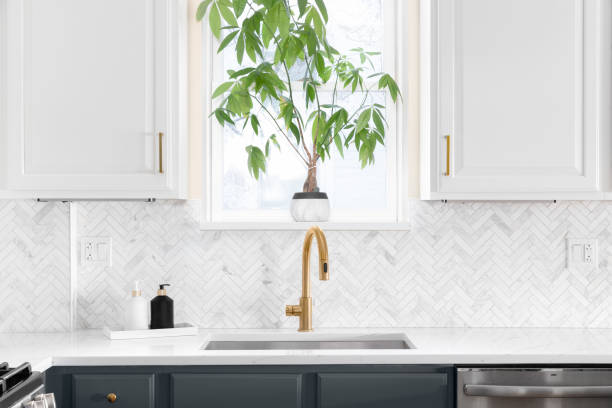 istock A gold kitchen faucet with a herringbone tile backsplash. 1455836039