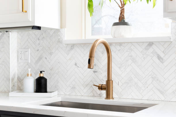 istock A gold kitchen faucet with a herringbone tile backsplash. 1455836051