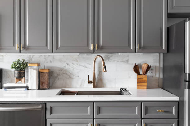 istock A gold kitchen faucet detail with grey cabinets. 1455836080