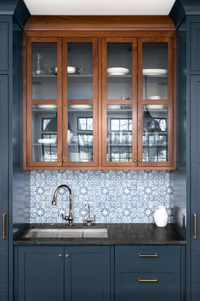 istock A kitchen sink detail with blue cabinets and tiled backsplash. 1455836112