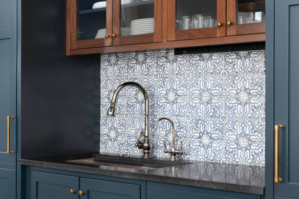 istock A kitchen sink detail with blue cabinets and tiled backsplash. 1455836144