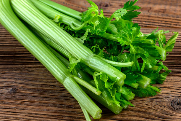 istock Bunch of fresh celery on wooden background 1455837209