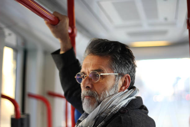 istock Senior positive man in city bus 1455839661