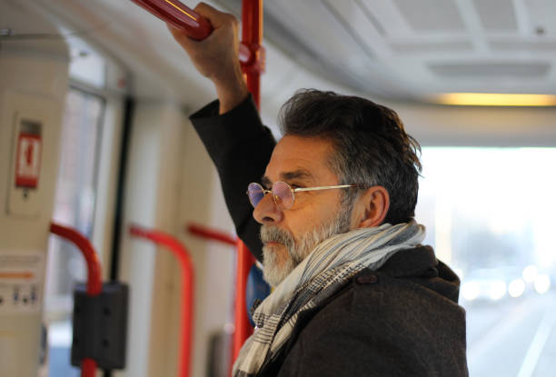 istock Senior positive man in city bus 1455839663