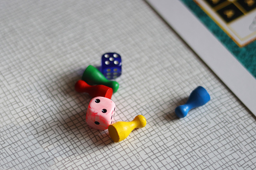 Ready for a board game. Colored chips and playing dices laid out on a kitchen table. Table game for a whole family. Selective focus. Blurred