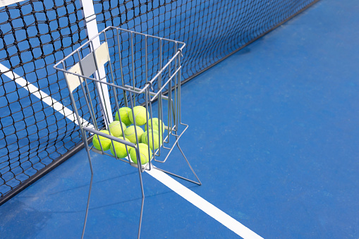 Basket of tennis balls near the net